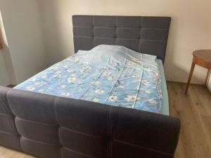 Bett mit blauer Decke in einem Zimmer in der Unterkunft Wohnung in Sigriswil