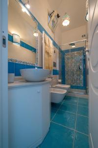a blue bathroom with two sinks and a shower at Ravello Dream Charming House in Scala