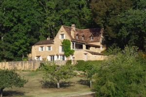 une ancienne maison en pierre au milieu d'une forêt dans l'établissement Roquecombe, à La Roque-Gageac