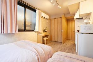 een kleine kamer met een bed en een koelkast bij New Designed apart ment Shin-Okubo Sta 3 min walk in Tokyo