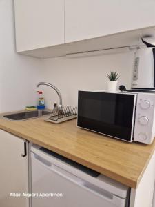 a microwave oven sitting on top of a kitchen counter at Altair Airport Apartman in Vecsés