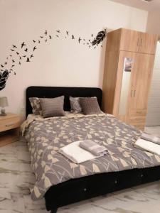 a bedroom with a bed with birds on the wall at Casagrande Studio in Kriopigi