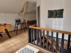 una sala de estar con una escalera con una tabla de surf en la pared en proche chateaux et zoo de beauval: gîte de sologne, en Pruniers