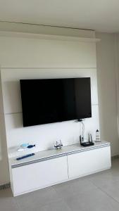 a large flat screen tv on a white wall at Resort Villa das águas praia do saco in Estância