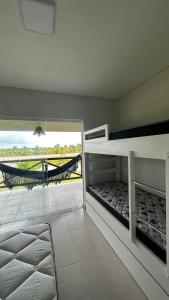 a bedroom with two bunk beds and a hammock at Resort Villa das águas praia do saco in Estância