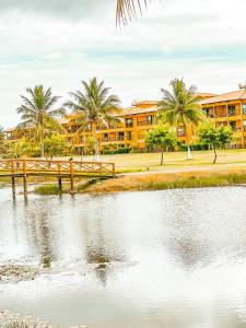 a resort with palm trees and a body of water at Resort Villa das águas praia do saco in Estância