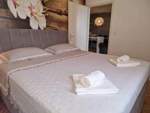- un grand lit blanc avec des serviettes dans l'établissement Apartment Pupila, à Solin