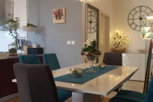 une salle à manger avec une table, des chaises et une horloge dans l'établissement Apartment Pupila, à Solin