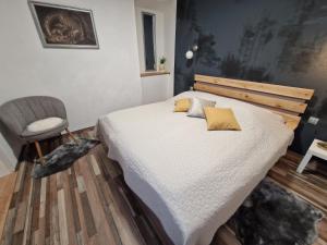 a bedroom with a large bed and a chair at FRIZ&FANY Postojna City Center in Postojna