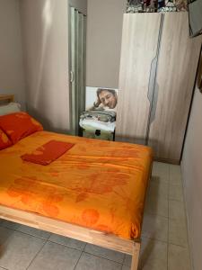 1 dormitorio con 1 cama con edredón de naranja en Holidays Pelion studio en Néa Ankhíalos