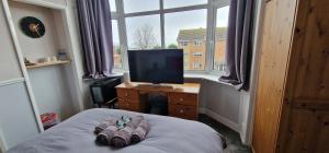 a bedroom with a bed with a television and a window at Cherrylee in Sandown