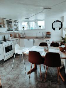 cocina con armarios blancos, mesa y sillas en Landstedet Billund, en Billund