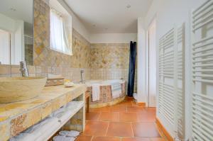 y baño con bañera, lavamanos y bañera. en Omma en Roussillon