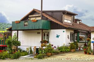 a white house with a green roof at Ferienwohnungen Claus in Frauenau +14 photos