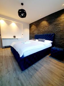 duża sypialnia z dużym łóżkiem i ścianą w obiekcie Galaxy Apartments w mieście Słupsk