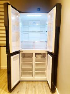 een lege koelkast met de deur open in een kamer bij Galaxy Apartments in Słupsk