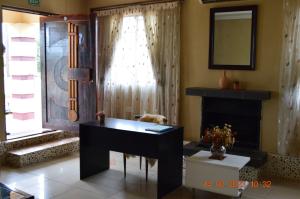 sala de estar con escritorio y chimenea en Glorious Home Bed & Breakfast en Mochudi