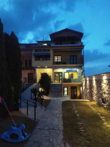 a building with a staircase in front of it at night at SmallHotel - Vevi in Vévi