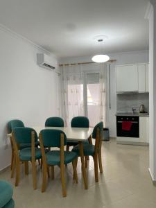 a kitchen and dining room with a table and chairs at Lungo mare holiday apartment for family in Vlorë