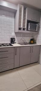 uma cozinha com um lavatório, um fogão e armários em Oceanic Unit 122 - Durban North Beach em Durban
