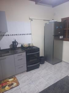 y cocina con fogones y nevera. en Departamento 1 Dormitorio 1 cama 2 plazas y 1 cama 1 plaza deplazable( para 2 chicos ) en Corrientes