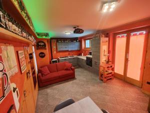 sala de estar con sofá rojo y cocina en Casa Vacanza Relax Sondrio, en Sondrio