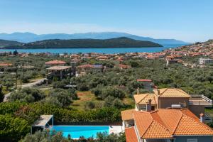 arial view of a villa with a swimming pool and a city at SUN VILLA GLYFADA in Glyfada Fokidas