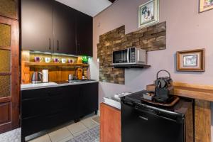 kuchnia z czarnymi szafkami i kuchenką mikrofalową w obiekcie Apartament gościnny w Niepołomicach +9 zdjęć