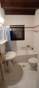 a white bathroom with a sink and a toilet at Sunhouse Vrachati in Vrahati