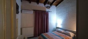 ein Schlafzimmer mit einem Bett und einem Fenster mit einem Vorhang in der Unterkunft Sunhouse Vrachati in Vrachati