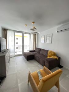 salon z kanapą i telewizorem w obiekcie Stylish Seaside 3 Bed Apartment with Terrace + Sea View w mieście Benalmádena