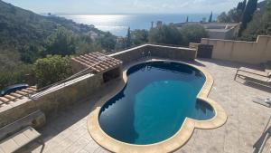 een zwembad op een patio met uitzicht op de oceaan bij Villa familiale piscine privée et magnifique vue mer in Roses