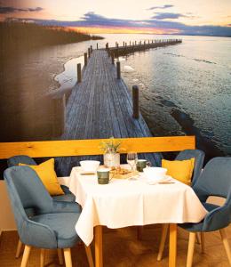 Villa Blue Apartman في سكسارد: طاولة مع كراسي وممشى في الماء