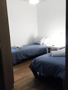 a bedroom with two beds and a table with two towels at MODERNO APARTAMENTO EN EL CENTRO in Vilanova i la Geltrú