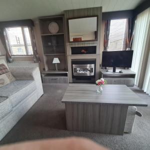 a living room with a couch and a coffee table at Oscars caravan in Abergele +13 photos