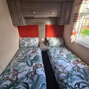 ein kleines Schlafzimmer mit 2 Betten in einem Wohnwagen in der Unterkunft Oscars caravan in Abergele