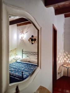 a mirror on a wall with a bed in a room at Lilibeth Houses - Charming & Lovely views in Scicli