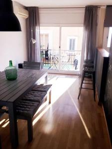 a living room with a wooden table and a large window at MODERNO APARTAMENTO EN EL CENTRO in Vilanova i la Geltrú