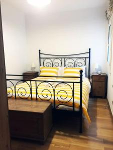 a bedroom with a black and yellow bed with yellow pillows at MODERNO APARTAMENTO EN EL CENTRO in Vilanova i la Geltrú
