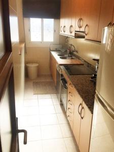 eine kleine Küche mit einem Waschbecken und einem Fenster in der Unterkunft MODERNO APARTAMENTO EN EL CENTRO in Vilanova i la Geltrú