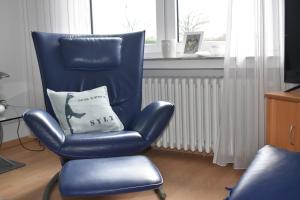 a blue chair with a pillow in a living room at FeWo am Naturschutzgebiet in Hiddenhausen