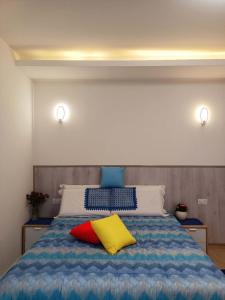 una camera con un letto con due cuscini sopra di Arcobaleno Rooms Venezia-Mestre a Mestre