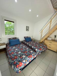 - une chambre avec un lit, une couette et un escalier dans l'établissement la dent du loup à la campagne, proche de Grenoble, à Noyarey