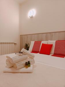 una camera con due letti, con asciugamani e cuscini rossi di Arcobaleno Rooms Venezia-Mestre a Mestre