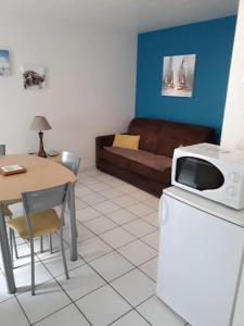 sala de estar con sofá y mesa con microondas en Duplex entier 2 personnes centre ville, en Audierne