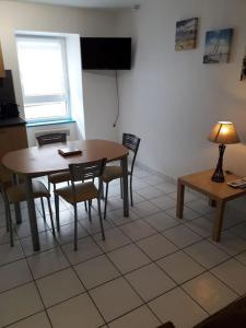 comedor con mesa, sillas y ventana en Duplex entier 2 personnes centre ville, en Audierne