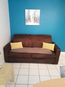 un sofá marrón en una sala de estar con una pared azul en Duplex entier 2 personnes centre ville, en Audierne