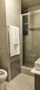 a bathroom with a shower and a toilet and towels at Oceanic Unit 122 - Durban North Beach in Durban