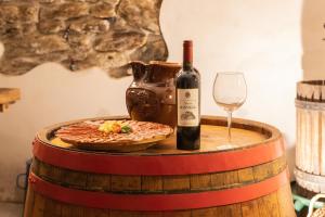 a bottle of wine and a pizza and a glass at Grunt Sonek in Mislinja