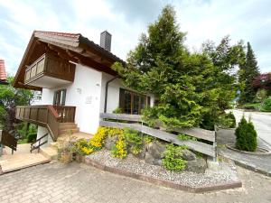 a small white house with a fence and trees at Villa Angélique in Bad Kohlgrub